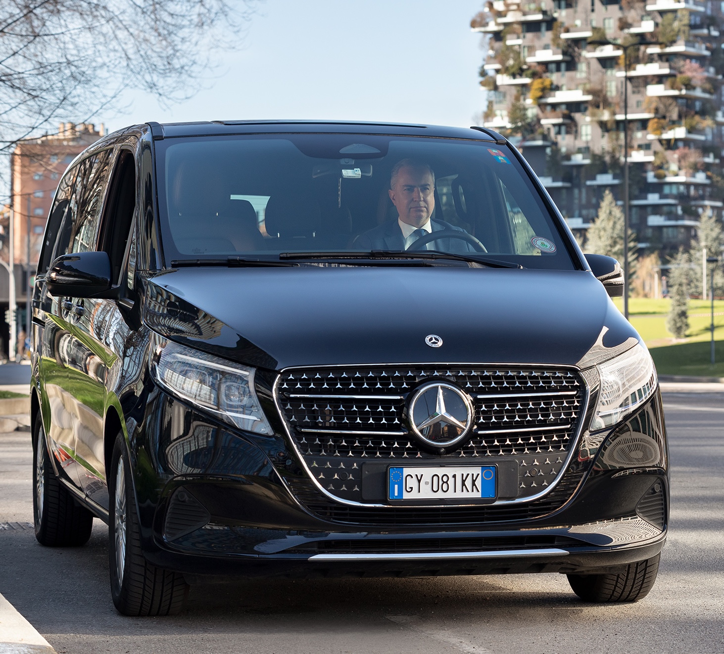 Professional chauffeur driving a Mercedes V-Class for diplomatic and VIP transport service in Milan